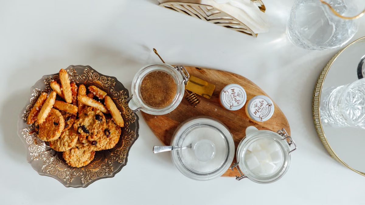 Aerial view of cookies and snacks with condiments on a decorated table setting.
